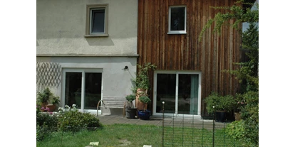 Rollstuhlgerechte Unterkunft - Unterkunftsart: Ferienhaus - Terrasse (mit Morgensonne)
Zugang von Wohnzimmer (links) und Küche (rechts) über schwellenlose Schiebetüren. - Sophies Haus