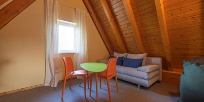 Rollstuhlgerechte Unterkunft - Unterkunftsart: Ferienhaus - Spitzboden mit Schlafcouch (Zugang über ein Doppelschlafzimmer) - Reetdachhaus mit Schwimmteich in Krienke