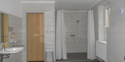 Rollstuhlgerechte Unterkunft - Unterkunftsart: Ferienhaus - Behindertengerechtes Badezimmer mit großer Dusche und Duschhocker - Ferienhaus Amelsberg