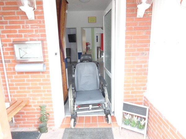 Rollstuhl-Urlaub: Beispielfoto mit einem Pflegerollstuhl in der Eingangstür vom Ferienhaus - Ferienhaus Amelsberg