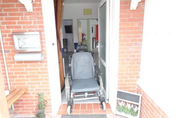 Rollstuhl-Urlaub: Beispielfoto mit einem Pflegerollstuhl in der Eingangstür vom Ferienhaus - Ferienhaus Amelsberg