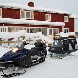 Rollstuhl-Urlaub: Our snowmobile and pulka can transport you into the most magical winter forests, where we can enjoy coffee and food cooked over an open fire.. - The Friendly Moose Lapland