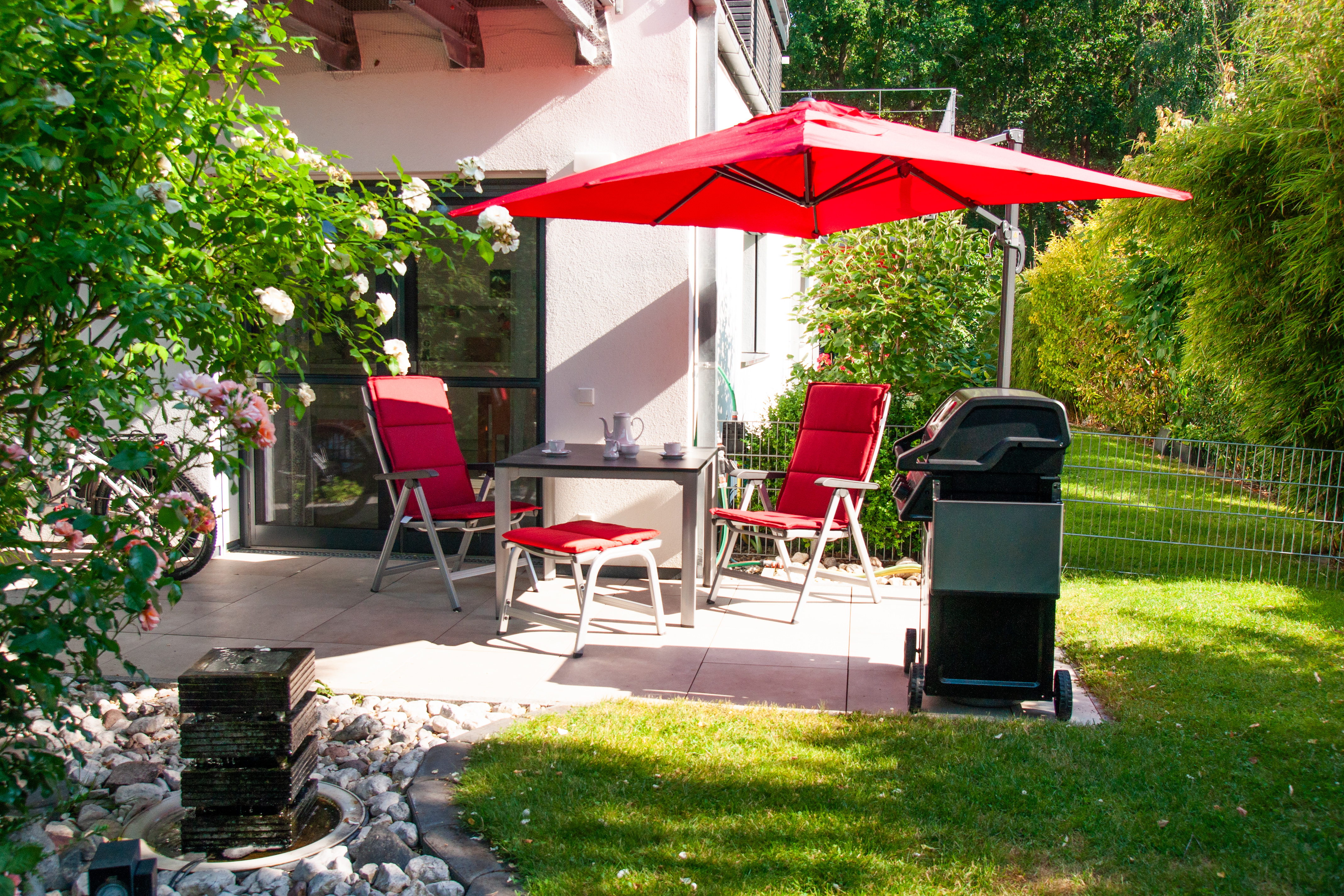 Rollstuhl-Urlaub: Terrasse mit Gasgrill und Brunnen, dieser ist Nachts beleuchtet - Ferienapartment im Haus Rügin