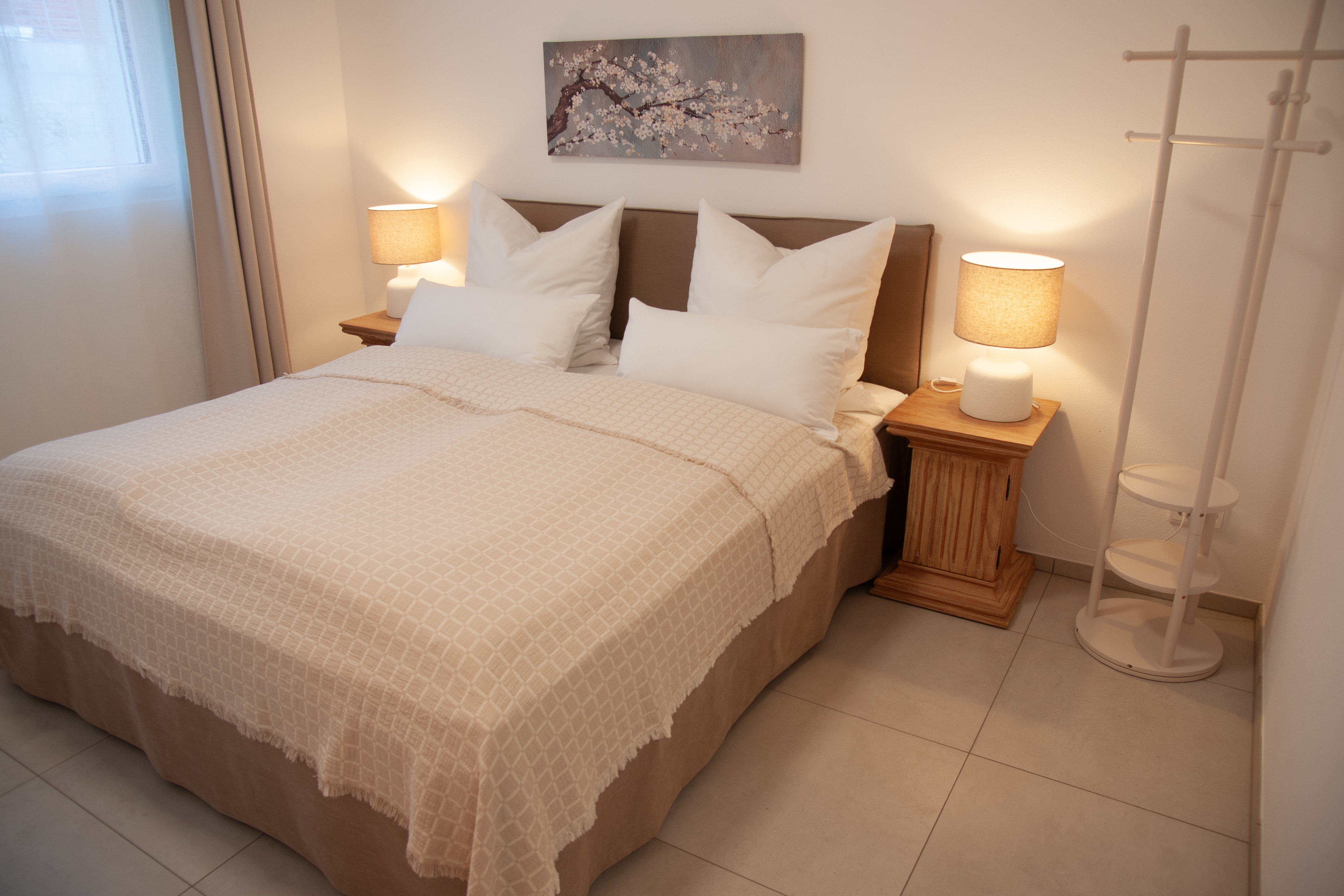 Rollstuhl-Urlaub: Schlafzimmer mit Boxspringbett und Schiebetürenschrank. Platzangebot Bett/Spiegel 110 cm, Bett/Schrank/Fenster 70 cm. - Ferienapartment im Haus Rügin