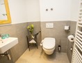 Rollstuhl-Urlaub: Separate Toilette mit schwenkbaren Haltegriff und Popdusche - Alp Chalet Kleinwalsertal