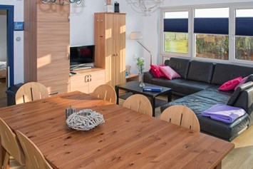 Rollstuhl-Urlaub: Esstisch und gemütliche Couch des Ferienhauses - Modestia Groepsverblijf Texel