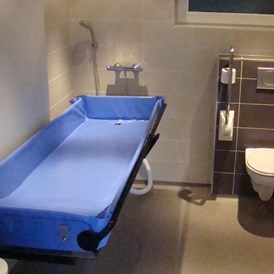 Rollstuhl-Urlaub: Duschliege - Behindertengerechte Gruppenunterkunft auf Ameland (Niederlande)