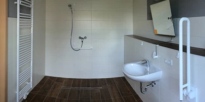 Rollstuhlgerechte Unterkunft - Unterkunftsart: Ferienhaus - Ferienhof Lamp Badezimmer mit ebenerdiger Dusche und klappbaren Haltegriffen - Rollstuhlgerechte Unterkünfte im Ferienhof Lamp