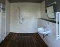Rollstuhlgerechte Unterkunft: Ferienhof Lamp Badezimmer mit ebenerdiger Dusche und klappbaren Haltegriffen - Rollstuhlgerechte Unterkünfte im Ferienhof Lamp