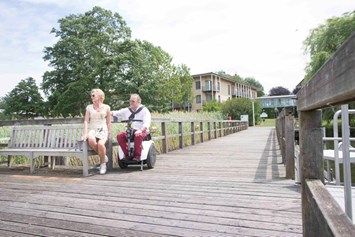 Rollstuhl-Urlaub: mit dem Rollstuhl befahrbarer Holzsteg - Seehotel Rheinsberg - komplett barrierefreies Hotel am See