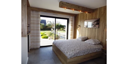 Rollstuhlgerechte Unterkunft - Unterkunftsart: Ferienhaus - Das geräumige Schlafzimmer mit Badezimmer links und Ausgang in den Garten - Ferienhaus Bretagne - Plouarzel