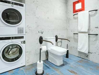 Rollstuhlgerechte Unterkunft - Unterkunftsart: Ferienhaus - Das barrierefreie Badezimmer der Mastersuite verfügt über eine Waschmaschine und einen Wäschetrockner. - Poolvilla mit phantastischem Ausblick - mit Pool Lifter
