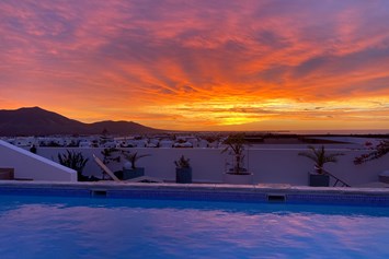 Rollstuhl-Urlaub: Sonnenaufgang - Blick von der Terrasse über Playa Blanca und zu den Vulkanbergen. - Poolvilla mit phantastischem Ausblick - mit Pool Lifter