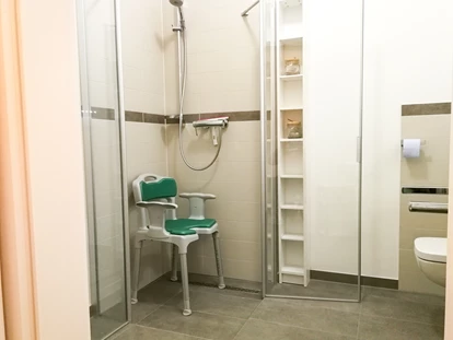 Rollstuhlgerechte Unterkunft - Die Dusche im barrierefreien Bad lässt sich komplett öffnen. Ein Duschstuhl steht natürlich kostenfrei auf Anfrage zur Verfügung. Auch ein Rutschbrett ist vorhanden. - MeerOstseeZeit