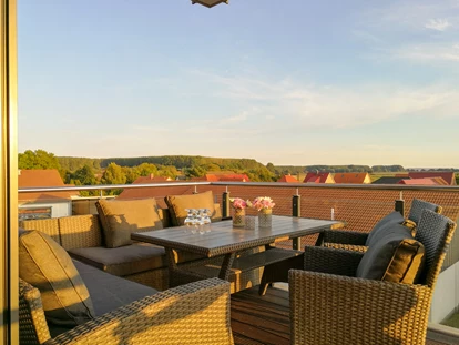 Rollstuhlgerechte Unterkunft - Damit du einen gemütlichen Aufenthalt auf dem Balkon hast, habe ich extra eine stabile Sitzecke mit breiter Sitzfläche und guten Auflagen ausgewählt. So kannst du deine Füße hochlegen, dich entspannt Sonnen , sowie auch bei Bedarf das Gesäß entlasten. Ich liege dort sehr gerne sogar seitlich drauf. Die Sitzecke steht fest und ermöglicht dadurch einen einfachen Transfer. Der Tisch kann bei Bedarf einfach zur Seite geschoben werden, denn der Balkon bietet genügend Freiraum. - MeerOstseeZeit