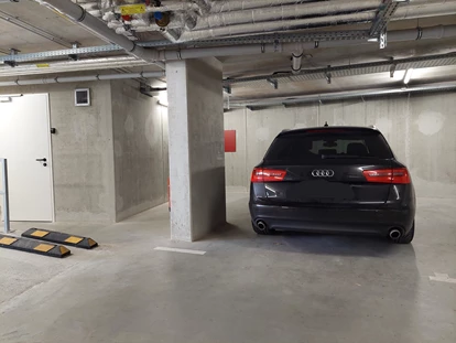 Rollstuhlgerechte Unterkunft - Hier seht ihr den behindertenfreundlichen Parkplatz. Der Durchgang zwischen Bodenmarkierung und Pfeiler ist ca. 80cm breit. - MeerOstseeZeit