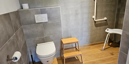Rollstuhlgerechte Unterkunft - Unterkunftsart: Ferienhaus - Dusche mit Haltegriff und auf Wunsch mit Duschstuhl - Erdhausapartment OST