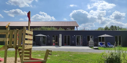Rollstuhlgerechte Unterkunft - Unterkunftsart: Ferienhaus - gegenüber liegender Spielplatz auf dem sie ihre Kinder, z.B. gemütlich bei einer Tasse Cappuccino, von ihrer Terrasse beobachten können - Erdhausapartment OST