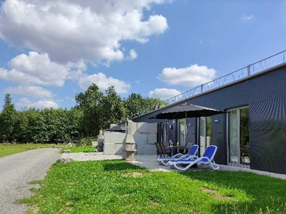 Rollstuhlgerechte Unterkunft - Unterkunftsart: Ferienhaus - Eingangsbereich Erdhausapartment WEST mit eigenem Parkplatz direkt am Haus, ebenerdigen Terrasse mit Grill - Erdhausapartment WEST