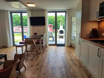 Rollstuhlgerechte Unterkunft - Unterkunftsart: Ferienhaus - Wohn-, Esszimmer mit direktem ebenerdigen Zugang auf die Terrasse - Erdhausapartment WEST