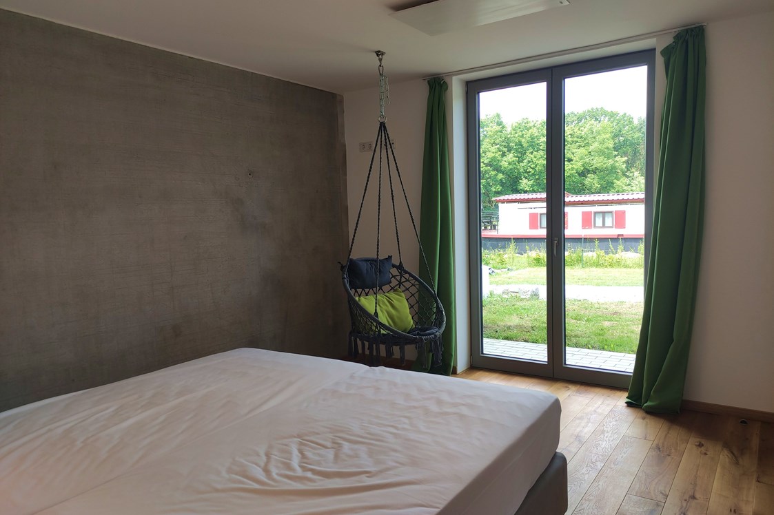 Rollstuhl-Urlaub:  erstes Schlafzimmer mit Doppelbett und ebenerdiger Ausgang auf die Terrasse - Erdhausapartment WEST