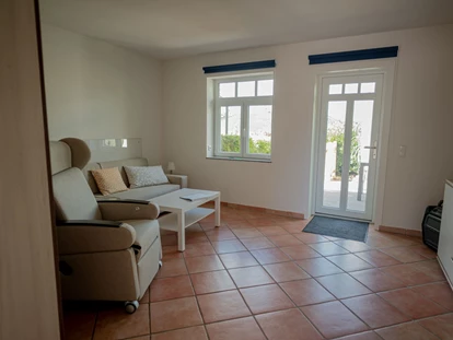 Rollstuhlgerechte Unterkunft - Unterkunftsart: Ferienhaus - Wohnzimmer in der Einliegerwohnung mit eigener Terrasse - Stiftung Friedrich Wilhelm und Monika Kertz