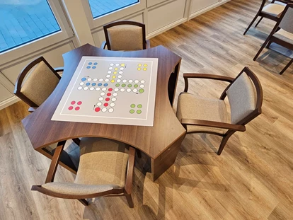 Rollstuhlgerechte Unterkunft - Unterkunftsart: Ferienhaus - Spieletisch mit Wechselplatte Mensch-ärger-dich-nicht - Stiftung Friedrich Wilhelm und Monika Kertz