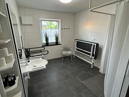 Rollstuhlgerechte Unterkunft - Unterkunftsart: Ferienhaus - Haus 2 - Großes Duschbad mit Wandklappliege - Stiftung Friedrich Wilhelm und Monika Kertz
