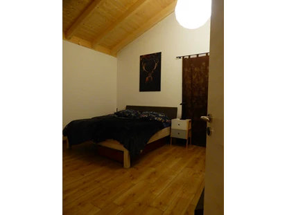 Rollstuhlgerechte Unterkunft - Unterkunftsart: Ferienhaus - Im großzügigen Schlafzimmer kann ein zweites Fernsehgerät aufgestellt werden. Die beiden Fenster gehen zum Bach und zum Garten, geniessen Sie die Ruhe ohne Verkerhrslärm. - Ferienhaus Wollinger